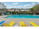 Community swimming pool with lounge chairs and surrounding residential buildings on a sunny day at 230 Silver Fox Trl, Dallas, GA 30157