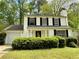 Charming two-story home featuring black shutters, a chimney, manicured bushes and a one-car garage at 3150 Berkshire Manor Dr, Alpharetta, GA 30022