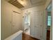 Hallway with hardwood floors leading to a full bathroom with vanity and storage at 3150 Berkshire Manor Dr, Alpharetta, GA 30022