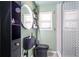 Stylish bathroom featuring modern fixtures, round mirror, shelving, black toilet, and glass-enclosed shower at 3385 Pinehill Dr, Decatur, GA 30032