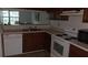 Practical kitchen with white appliances, wooden cabinets, and a view to the dining area at 340 Teal Ct, Roswell, GA 30076