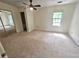 Large carpeted bedroom with ceiling fan, a closet with sliding doors, and a window allowing natural light at 1557 Springleaf Se Ct, Smyrna, GA 30080