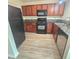Well-lit kitchen features wood cabinets, black appliances, and granite countertops at 1557 Springleaf Se Ct, Smyrna, GA 30080