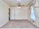 Neutral bedroom featuring a ceiling fan, carpet, and a window dressed with heavy curtains at 1245 Shore Dr, Atlanta, GA 30311