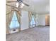 Bright bedroom with carpet flooring, ceiling fan and a pair of draped and lace curtained windows at 1245 Shore Dr, Atlanta, GA 30311