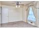 Bedroom showcasing a large window with drapes, carpet flooring, and a modern ceiling fan at 1245 Shore Dr, Atlanta, GA 30311
