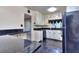 Well-lit kitchen with white cabinets, black appliances, and dark countertops at 1245 Shore Dr, Atlanta, GA 30311