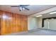 Spacious living room area with wood paneling, carpet, and access to a sliding glass door at 1245 Shore Dr, Atlanta, GA 30311