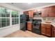 A modern kitchen with wood cabinets, black appliances, and a window providing natural light at 306 Teal Ct, Roswell, GA 30076