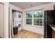 Dedicated laundry area with stacked washer and dryer next to kitchen, featuring a bright window at 306 Teal Ct, Roswell, GA 30076