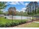 Community pool surrounded by a black metal fence and trees in a park-like setting at 306 Teal Ct, Roswell, GA 30076