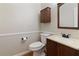 Cozy half bathroom featuring wooden vanity, neutral walls, and matching framed mirror at 540 Basil Sw Ct, Marietta, GA 30064