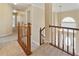 Upstairs hallway with neutral carpet, wooden railing, and an inviting view of the home's entryway at 540 Basil Sw Ct, Marietta, GA 30064