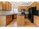 Spacious kitchen featuring wood cabinets, black appliances, an island and light-colored backsplash at 540 Basil Sw Ct, Marietta, GA 30064