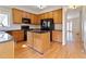 Kitchen view with wooden cabinets, black appliances, and a central island with dark countertops at 540 Basil Sw Ct, Marietta, GA 30064