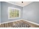 Bright, empty bedroom with a large window and wood-look flooring at 95 Hawthorn Ln, Covington, GA 30014
