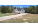 Exterior side view showcasing a well-maintained lawn, long driveway, and a charming two-story home at 95 Hawthorn Ln, Covington, GA 30014