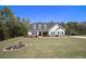 Charming two-story home featuring a manicured lawn and a classic white facade under a clear blue sky at 95 Hawthorn Ln, Covington, GA 30014
