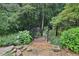 Landscaped backyard featuring stone steps and fencing, enhancing the natural setting at 4062 Vinings Mill Se Trl, Smyrna, GA 30080