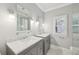 Bright, neutral bathroom featuring dual sinks, marble countertops, a glass shower, and modern fixtures at 4062 Vinings Mill Se Trl, Smyrna, GA 30080