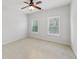 A neutral bedroom featuring carpet, two windows, a ceiling fan, and white trim at 4062 Vinings Mill Se Trl, Smyrna, GA 30080