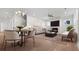 Open-concept living room and dining area with fireplace, modern lighting, and wood floors creating a welcoming space at 784 Keystone Dr, Woodstock, GA 30188