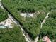 Scenic aerial view of a wooded lot with a charming house nestled in the trees surrounded by lush greenery at 1170 Upper Sweetwater Se Trl, White, GA 30184