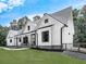Stunning modern farmhouse with white siding, black trim, inviting porch, and lush green lawn at 1170 Upper Sweetwater Se Trl, White, GA 30184