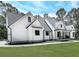 Elegant farmhouse featuring a covered porch, manicured lawn, and architectural design at 1170 Upper Sweetwater Se Trl, White, GA 30184