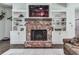 Cozy fireplace with brick surround, built-in shelving, and decorative accents at 1170 Upper Sweetwater Se Trl, White, GA 30184
