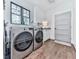 Well-equipped laundry room with stainless steel washer and dryer set, plus storage cabinets at 1170 Upper Sweetwater Se Trl, White, GA 30184