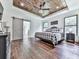 Serene main bedroom with a tray ceiling, wood flooring, and natural light from the windows at 1170 Upper Sweetwater Se Trl, White, GA 30184