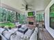 Covered porch featuring a brick fireplace, tv and comfortable furniture to enjoy the outdoors at 1170 Upper Sweetwater Se Trl, White, GA 30184