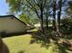 View of the backyard featuring green grass, mature trees, and the side of the home at 5516 Westberry Ln, Norcross, GA 30071
