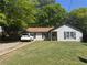 Charming one-story home with a well-manicured lawn and mature trees on a sunny day at 5516 Westberry Ln, Norcross, GA 30071