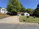 Quaint one-story home featuring a lush green lawn, a long driveway, and inviting curb appeal at 5516 Westberry Ln, Norcross, GA 30071