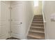Carpeted staircase with white trim and a small window for natural light leads to the upper level at 2641 Cacao Sq, Acworth, GA 30101