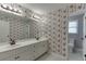 Bathroom with floral wallpaper, double vanity, white cabinetry, and a separate toilet room at 395 Highland Gate Cir, Suwanee, GA 30024