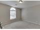 Empty bedroom featuring neutral walls, carpet, and a large arched window with blinds at 395 Highland Gate Cir, Suwanee, GA 30024
