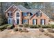 Beautiful two-story brick home featuring a well-manicured front yard and classic architectural details at 395 Highland Gate Cir, Suwanee, GA 30024