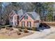 Charming brick home with a large driveway, lush landscaping, and a fenced backyard with a basketball hoop at 395 Highland Gate Cir, Suwanee, GA 30024