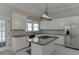 A well-lit kitchen featuring a central island cooktop, stainless appliances, and sleek granite countertops at 395 Highland Gate Cir, Suwanee, GA 30024