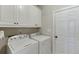 Functional laundry room with modern washer and dryer, ample cabinet storage, and convenient access to utilities at 395 Highland Gate Cir, Suwanee, GA 30024