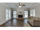 Cozy living room features hardwood floors, fireplace with mantel, large windows, and neutral paint scheme at 395 Highland Gate Cir, Suwanee, GA 30024