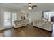 Bright living room featuring hardwood floors, neutral paint, crown molding, and natural light through the windows at 395 Highland Gate Cir, Suwanee, GA 30024