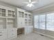 Well-lit home office featuring custom built-in shelving, cabinets, and drawers next to large windows at 395 Highland Gate Cir, Suwanee, GA 30024