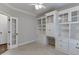 Bright home office with custom built-in shelving, drawers, cabinets, and a view of the door at 395 Highland Gate Cir, Suwanee, GA 30024