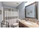 Well-lit bathroom featuring granite countertops, wood vanity, and a shower with neutral shower curtain at 4037 Hill Station Ct, Sugar Hill, GA 30518