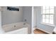 Bright bathroom featuring a soaking tub, glass shower, and large window at 4037 Hill Station Ct, Sugar Hill, GA 30518