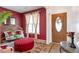 Stylish living room with a decorative front door, a red accent wall, and comfortable furnishings at 4037 Hill Station Ct, Sugar Hill, GA 30518